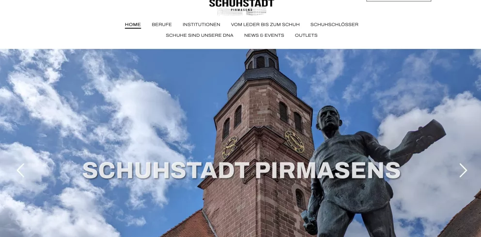 Schriftzug Schuhstadt Pirmasens im Hintergrund ist ein Rathausturm aus Sandsteinen zu sehen
